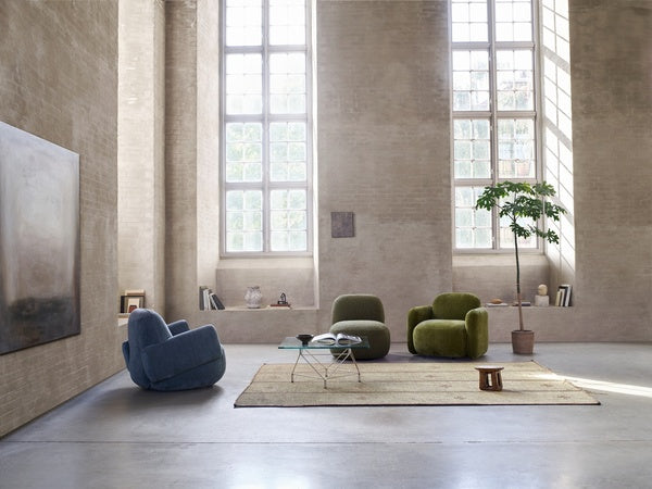 Close-up of Havana Lounge Chairs by Eilersen in green velvet, placed in a bright room with tall windows and a potted plant.
