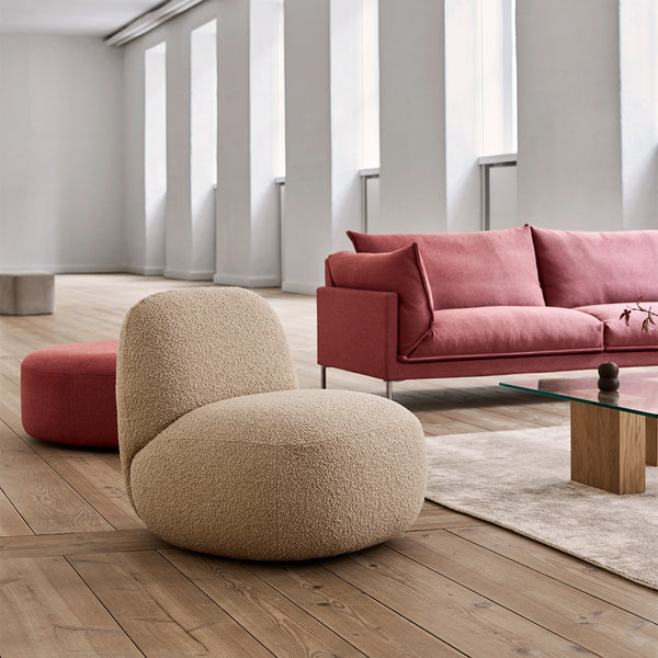 Butterfly Sofa by Eilersen in a spacious room with soft lighting, paired with a boucle lounge chair and ottoman for a cozy, modern setup.