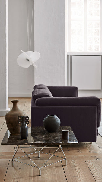 Side view of the Eilersen Tub Sofa in Plindy 16 fabric, paired with a marble and chrome coffee table in a minimalist interior.