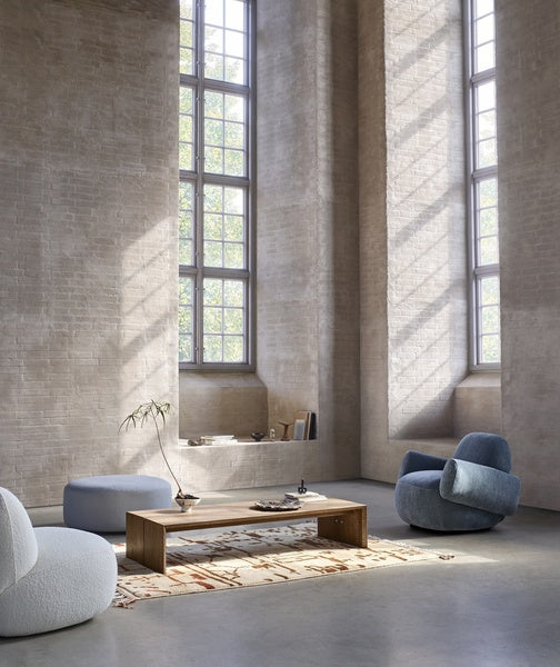 Modern loft with Havana Lounge Chairs by Eilersen in green and blue, styled with a glass coffee table and natural lighting.