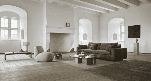 Modern living room featuring the Amon Sofa by Eilersen, paired with a glass coffee table and soft lighting for a cozy ambiance.