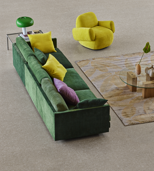 Minimalist living room with Havana Round Arm Chair and ottoman by Eilersen in white boucle, styled with wood shelving.