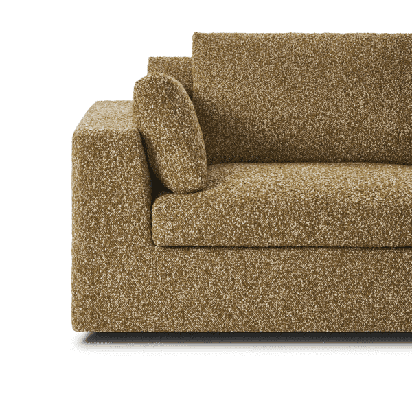 Close-up of Amon Sofa by Eilersen armrest and cushion detail in golden boucle, showcasing its plush texture and refined tailoring.