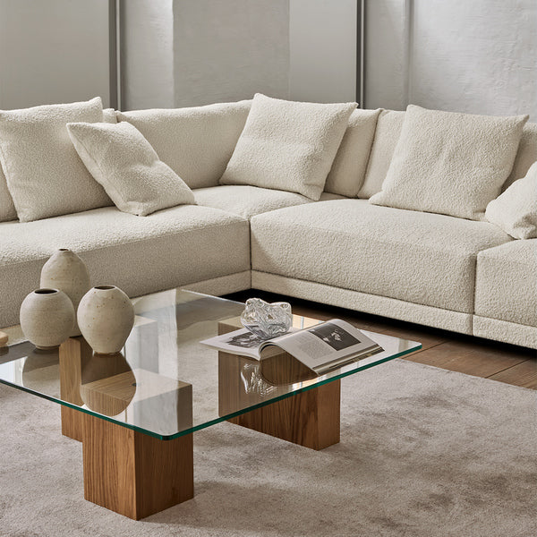 Close-up of Eilersen Drop Sectional with textured cream cushions and glass coffee table, highlighting plush comfort and modern design.