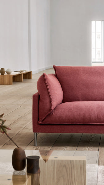 Close-up of Butterfly Sofa by Eilersen showcasing plush cushions and tailored seams in rose fabric, highlighting its refined yet relaxed design.