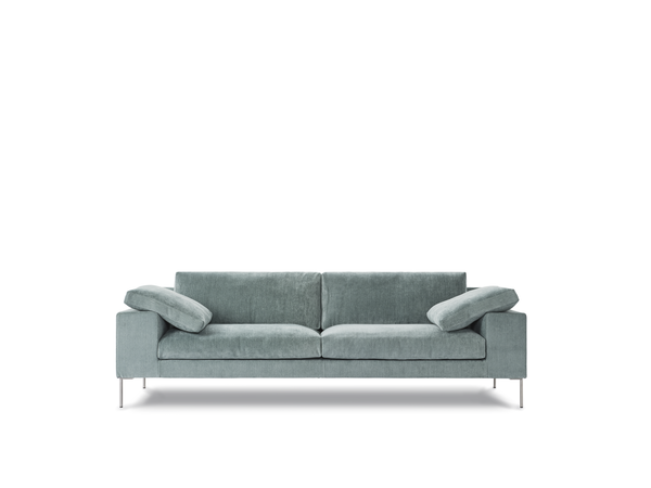 Front view of Shu Sofa by Eilersen in soft blue upholstery with plush cushions and sleek metal legs, ideal for contemporary interiors.