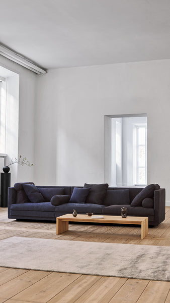 Cocoon Sofa by Eilersen at Trade Source Furniture in navy fabric, shown in a modern living space with neutral tones and minimalist furnishings.