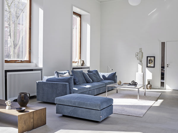 Light blue Float Sofa by Eilersen with ottoman in a sunlit modern interior. Available at Trade Source Furniture in quick ship options.