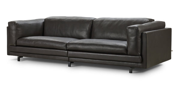Angled view of the Tub Sofa by Eilersen in dark brown leather, showcasing its structured arms and plush seating.