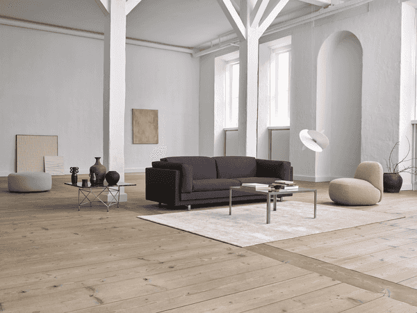 Tub Sofa by Eilersen in a spacious modern living room, styled with neutral decor and natural wood flooring at Trade Source Furniture.