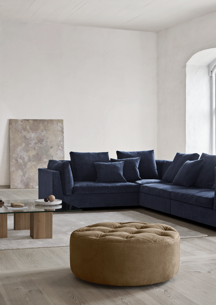Navy blue Float Sofa sectional by Eilersen with tan ottoman and modern decor. Available at Trade Source Furniture in various fabrics.