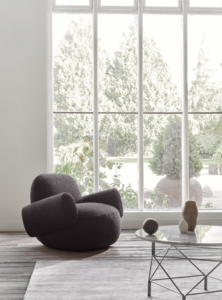 Minimalist corner with Havana Lounge Chair by Eilersen in light fabric, styled with a wood bench and brass floor lamp.