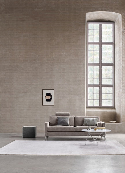 Quick Ship Lift Sofa by Eilersen in a tall-windowed loft space, styled with throw pillows and a white area rug for a contemporary furniture look.