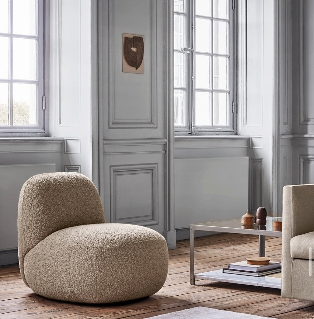 Havana Round Arm Chair by Eilersen in neutral boucle fabric, placed in a classic interior with paneled walls and wood flooring.