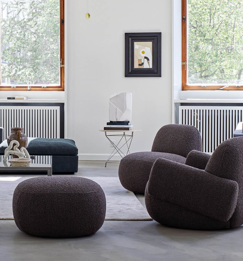 Living room setup featuring Havana Round Arm Chairs by Eilersen in dark boucle, styled with a matching ottoman and modern decor.