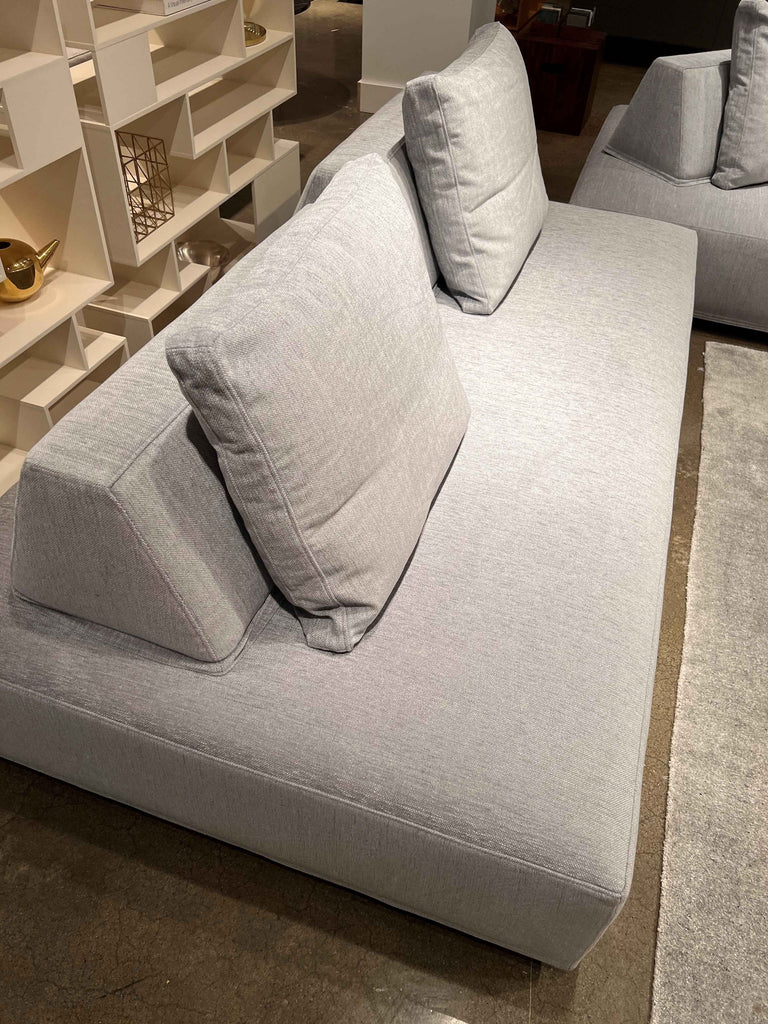Close-up of Eilersen Playground Sofa in showroom, showcasing its light grey upholstery and movable backrest design.