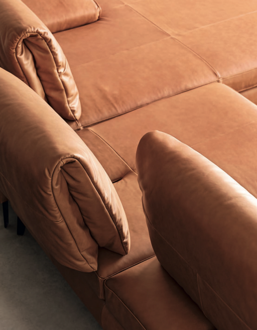 Luxurious brown leather sectional sofa with adjustable backrests, perfect for customizable comfort and stylish living room decor.