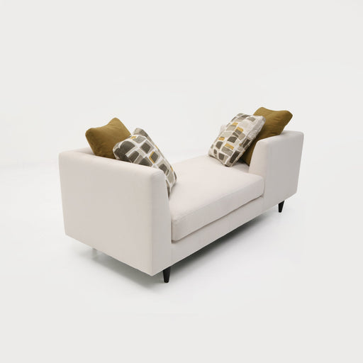 A modern white sofa with four decorative pillows, featuring geometric patterns and earthy tones, part of the Trade Source Furniture Collection.
