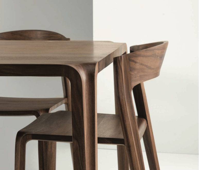 Close-up of elegant solid wood dining table and chairs with smooth, polished surfaces, showcasing high-quality craftsmanship for maintaining solid wood furniture.