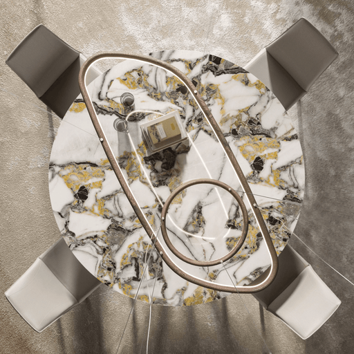 A top-down view of a modern, round marble dining table with a gold and black veined pattern, surrounded by four white upholstered chairs, showcasing Ozzio Italia's multifunctional furniture design.