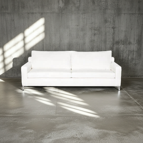 White sofa in a room with concrete walls and floor