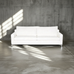 White sofa in a room with concrete walls and floor