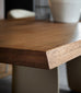 Close-up of a wooden dining table with a wider shot of a dining room setup.
