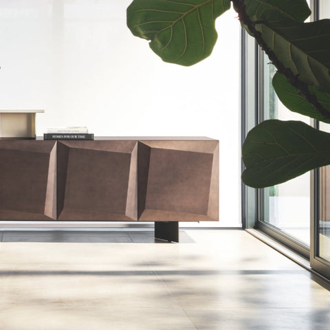 Modern interior with a wooden sideboard, chairs, and decorative items in a bright room.