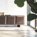 Modern interior with a wooden sideboard, chairs, and decorative items in a bright room.