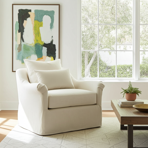 Beige armchair in a living room with abstract art and a window in the background