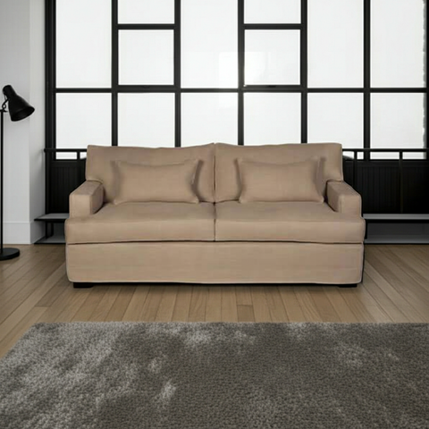Beige sofa in a room with large windows and a gray rug.