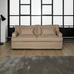 Beige sofa in a room with large windows and a gray rug.