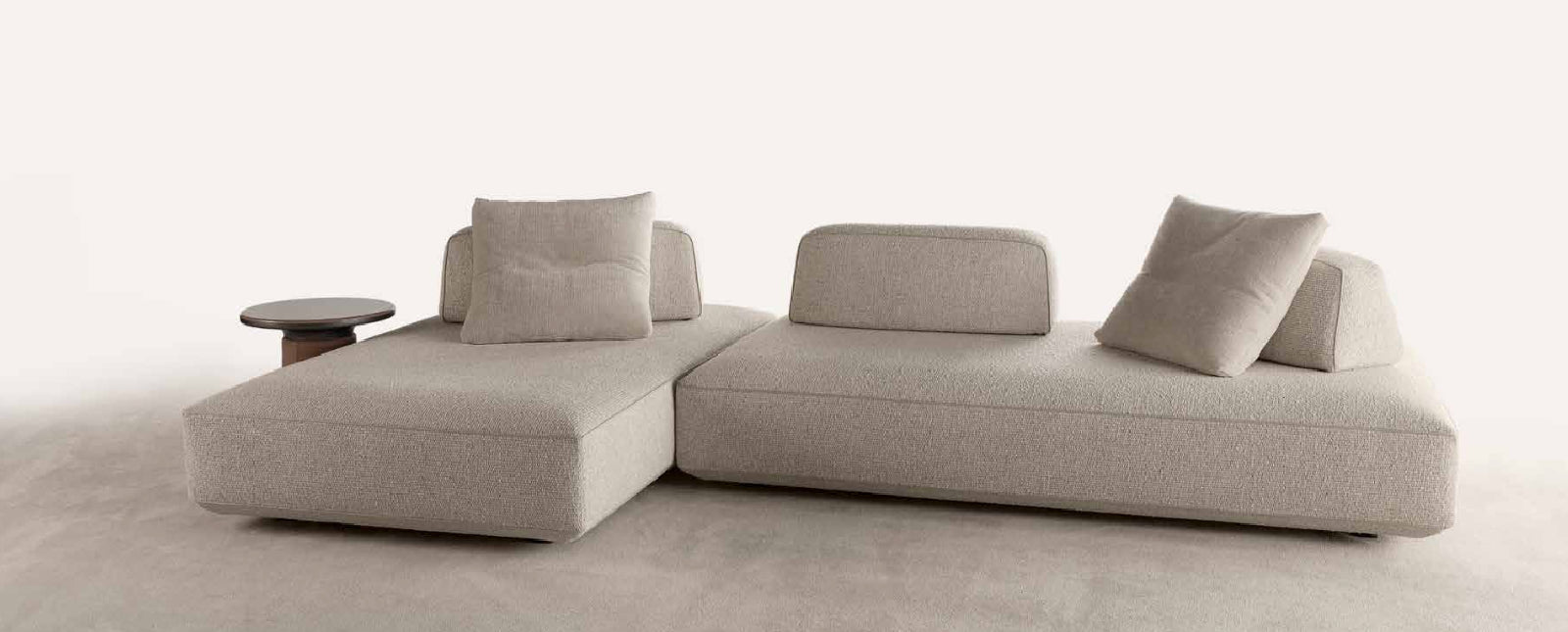 Gray sectional sofa with movable cushions on a white background