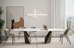 Modern dining room with a sleek table and chairs, abstract art, and a large window.