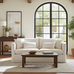 Living room with a white sofa, wooden coffee table, and large arched window.