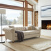 Beige sofa in a modern living room with large windows, fireplace, and TV.