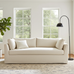 Beige sofa in a room with large windows and a plant