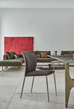 Dark velvet dining chair with curved backrest and slim metal legs, suitable for contemporary dining or lounge areas