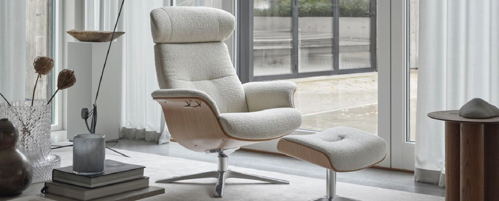 Modern armchair with ottoman in a bright room with large windows