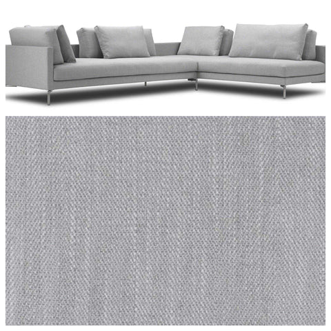 Dark gray sectional sofa with a sleek design in a living room with large windows, modern lighting, and minimalist decor